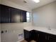 Well-equipped laundry room with dark cabinets, ample counter space, and a sink at 1027 Cambridge Park St, Las Vegas, NV 89148