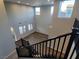 High-ceilinged living room, view from staircase, with many windows providing abundant natural light and wood-look floors at 1027 Cambridge Park St, Las Vegas, NV 89148