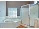 Bright bathroom with tub, glass block window and glass enclosed shower at 10513 Longwood Dr, Las Vegas, NV 89134