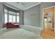 Bedroom featuring cozy chair, neutral carpet, and bright windows with shutters at 10513 Longwood Dr, Las Vegas, NV 89134