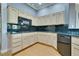 A kitchen featuring natural wood cabinets, wooden floors and black appliances and countertops at 10513 Longwood Dr, Las Vegas, NV 89134