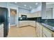 Charming kitchen with black countertops, natural wood cabinets and wooden floor at 10513 Longwood Dr, Las Vegas, NV 89134