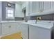 Well-lit laundry room featuring bright white cabinetry, modern appliances, and tile flooring at 10513 Longwood Dr, Las Vegas, NV 89134