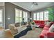 Comfortable living room with neutral tones, wood-style floors and big windows with white shutters at 10513 Longwood Dr, Las Vegas, NV 89134