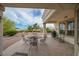 Covered outdoor patio with table and chairs, overlooking landscaped backyard at 10513 Longwood Dr, Las Vegas, NV 89134