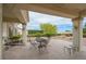 Covered outdoor patio with table and chairs offering an expansive landscaped yard at 10513 Longwood Dr, Las Vegas, NV 89134