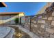 Backyard stream water feature with desert landscaping and attractive stone wall feature at 1060 Neil Armstrong Cir, Las Vegas, NV 89145