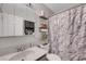 Neutral-toned bathroom featuring a shower and tub, and tiled walls at 1060 Neil Armstrong Cir, Las Vegas, NV 89145
