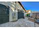 Exterior backyard view with mature desert landscaping, stone paver, and metal doors at 1060 Neil Armstrong Cir, Las Vegas, NV 89145