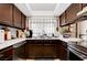 Traditional-style kitchen features dark wood cabinets, white countertops, and a stainless steel dishwasher at 1060 Neil Armstrong Cir, Las Vegas, NV 89145