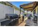 Cozy outdoor kitchen area with built-in BBQ, patio cover, and charming brick pavers at 1060 Neil Armstrong Cir, Las Vegas, NV 89145