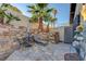 Charming patio features stone flooring, seating, palm trees, and rock wall feature at 1060 Neil Armstrong Cir, Las Vegas, NV 89145