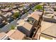 An aerial view of a modern home with a rooftop patio featuring an outdoor kitchen in a residential neighborhood at 10750 Red Badge Ave, Las Vegas, NV 89166