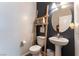 Stylish powder room with pedestal sink, dark accent wall, and decorative ladder shelf at 10750 Red Badge Ave, Las Vegas, NV 89166