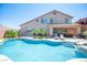 Stunning backyard oasis with a sparkling pool, lush landscaping, and a covered patio at 11112 Pine Greens Ct, Las Vegas, NV 89144