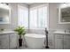 Bright bathroom featuring dual vanities and a freestanding tub by shuttered windows at 11112 Pine Greens Ct, Las Vegas, NV 89144
