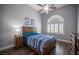 Cozy bedroom featuring a ceiling fan, a wooden bed frame, and a window providing ample natural light at 11112 Pine Greens Ct, Las Vegas, NV 89144