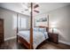 Cozy bedroom features a four-poster bed, ceiling fan, wood floors and a bright window with shutters at 11112 Pine Greens Ct, Las Vegas, NV 89144