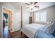 Comfortable bedroom with a four-poster bed, ceiling fan, wood floors and a door to the ensuite at 11112 Pine Greens Ct, Las Vegas, NV 89144