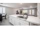 A kitchen featuring marble countertops, white cabinets, and an open layout to the living area at 11112 Pine Greens Ct, Las Vegas, NV 89144