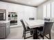 A close-up of the kitchen's dining area featuring a marble table, black chairs, and white built-in storage at 11112 Pine Greens Ct, Las Vegas, NV 89144