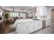 A kitchen with white cabinets, marble counters, and an open view to the living room with hardwood flooring at 11112 Pine Greens Ct, Las Vegas, NV 89144