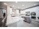 Bright kitchen with a large marble island, white cabinetry, stainless steel appliances, and modern fixtures at 11112 Pine Greens Ct, Las Vegas, NV 89144