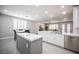 Open-concept kitchen with island, white cabinets, stainless appliances, and view of the living room at 11112 Pine Greens Ct, Las Vegas, NV 89144