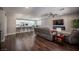 Open-concept living room with wood floors, a ceiling fan, and access to the kitchen and dining area at 11112 Pine Greens Ct, Las Vegas, NV 89144