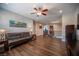 A large living room with hardwood floors, ceiling fan, and comfortable seating, with a staircase visible at 11112 Pine Greens Ct, Las Vegas, NV 89144