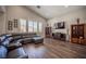 Open-concept living room with vaulted ceilings, natural light, and comfortable leather seating at 11112 Pine Greens Ct, Las Vegas, NV 89144