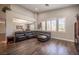 Spacious living room featuring a large leather sectional, high ceilings, and bright, natural lighting at 11112 Pine Greens Ct, Las Vegas, NV 89144