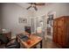 Bright home office featuring a ceiling fan, wood floors, and glass doors at 11112 Pine Greens Ct, Las Vegas, NV 89144