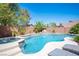 Beautiful backyard pool with a rock waterfall feature, attached spa and desert landscaping at 11112 Pine Greens Ct, Las Vegas, NV 89144