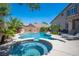 Backyard pool with a spa, rock waterfall feature, desert landscaping and space for outdoor seating at 11112 Pine Greens Ct, Las Vegas, NV 89144
