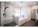 Luxurious bathroom with a soaking tub, dual shower heads, and walk-in closet access at 11119 River Hills Ln, Las Vegas, NV 89135