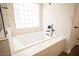 Relaxing soaking tub offers marble details and a black matte faucet and shower head at 11119 River Hills Ln, Las Vegas, NV 89135