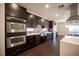 Modern kitchen with stainless steel appliances, a breakfast bar, and dark wood cabinetry at 11119 River Hills Ln, Las Vegas, NV 89135