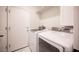 Well-lit laundry room featuring a side-by-side washer and dryer with white tile flooring at 11119 River Hills Ln, Las Vegas, NV 89135