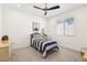 Bright bedroom with a single bed with blue striped bedding and a ceiling fan at 12155 Sage Thunder Ave, Las Vegas, NV 89138