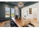 Well-lit dining area featuring a wooden table, woven light fixtures, and white trim windows at 12155 Sage Thunder Ave, Las Vegas, NV 89138