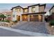 Beautiful home exterior with a brick driveway, well-maintained landscaping, and a three-car garage at 12155 Sage Thunder Ave, Las Vegas, NV 89138