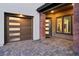 Close up of modern two-car garage and front door with brick and stone accents on a brick driveway at 12155 Sage Thunder Ave, Las Vegas, NV 89138