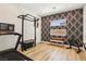 Home gym featuring a treadmill, weight rack, accent wall, and natural light from two windows at 12155 Sage Thunder Ave, Las Vegas, NV 89138