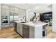 Modern kitchen featuring stainless steel appliances, an island, and open access to the staircase at 12155 Sage Thunder Ave, Las Vegas, NV 89138