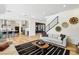 Open concept living room with hardwood floors leading to a modern kitchen and staircase at 12155 Sage Thunder Ave, Las Vegas, NV 89138