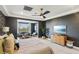 Bright main bedroom features dark accent walls, a cozy sitting area, and modern ceiling fan at 12155 Sage Thunder Ave, Las Vegas, NV 89138