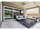This covered patio features a comfortable seating area, a ceiling fan, and sliding glass doors for seamless indoor-outdoor living at 12155 Sage Thunder Ave, Las Vegas, NV 89138