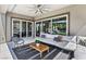 Cozy patio with ample seating, a stylish rug, and multiple sliding glass doors offers an inviting space for relaxing and entertaining at 12155 Sage Thunder Ave, Las Vegas, NV 89138