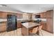 Kitchen with wood-style flooring, central island, granite countertops, and dark appliances at 1536 Leatherleaf Dr, Las Vegas, NV 89123
